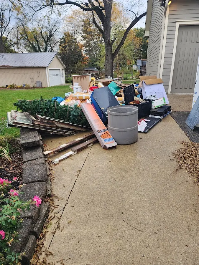 Dumpster being loaded with debris for Estate Cleanout Dumpster Rental in Lynbrook